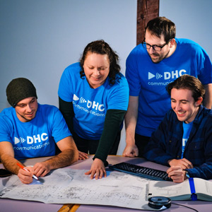DHC staff planning a project with building blueprints sitting on a boardroom table